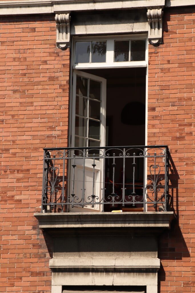 balcón con la puerta abierta en un edificio de ladrillo